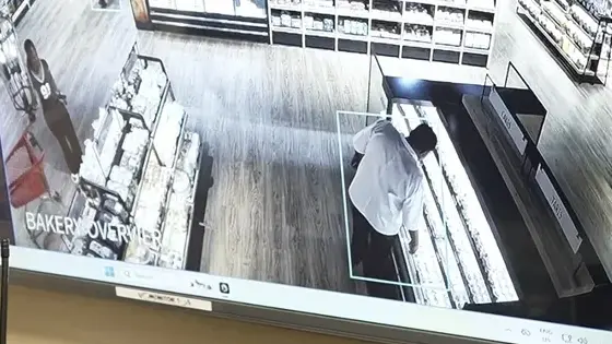 Video analytics drawing a detection box around a shopper at a store bakery counter on a live CCTV view