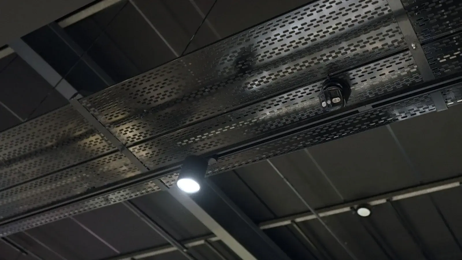 CCTV installation in Gauteng: CCTV dome camera mounted on a black cable tray under a store ceiling