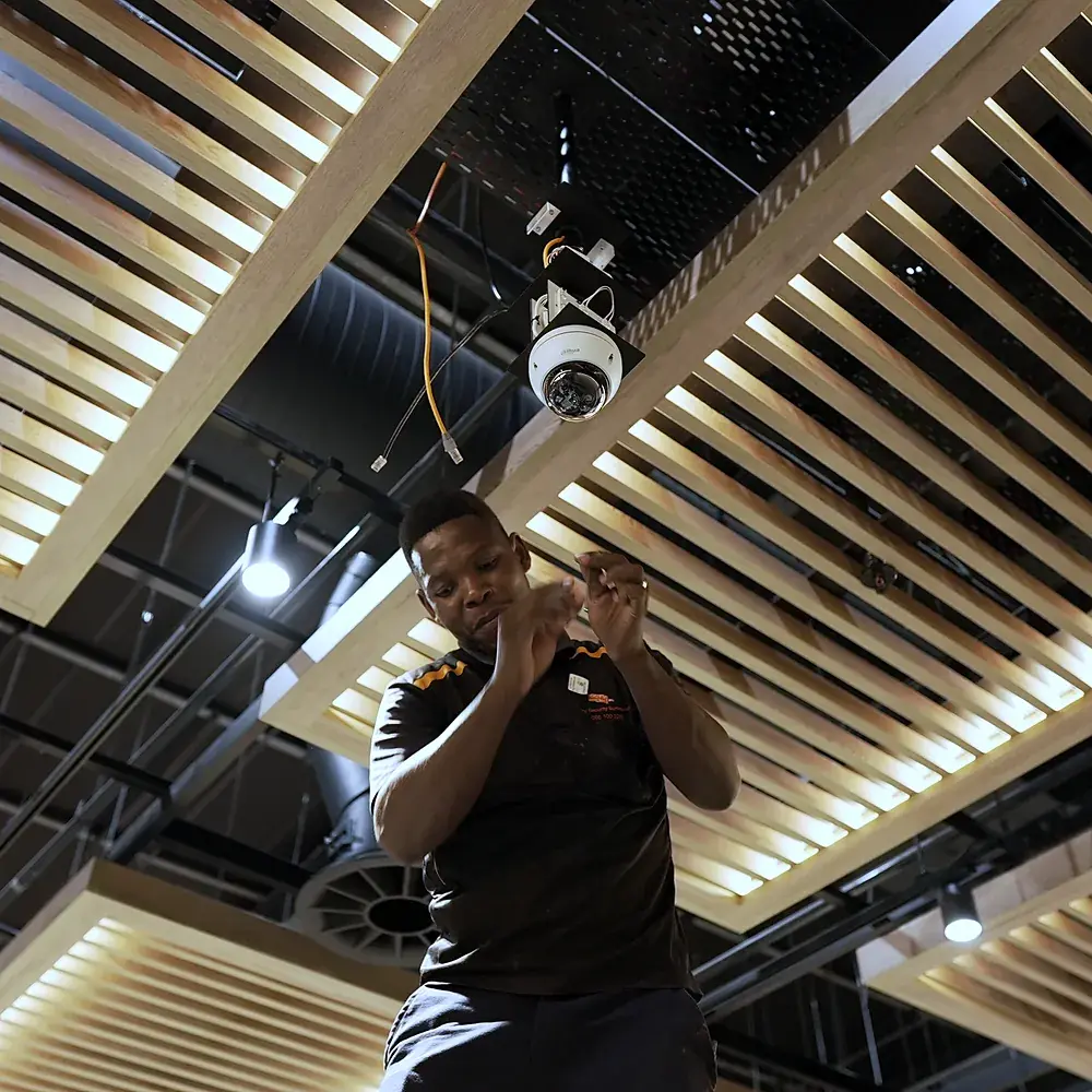 CCTV Security Surveillance technician installing a CCTV dome camera in a store ceiling