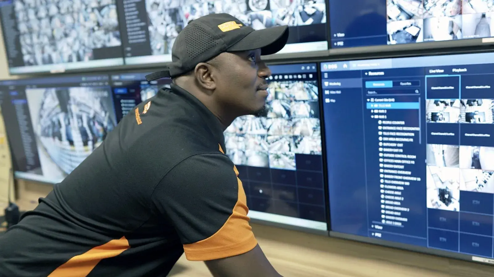 Offsite CCTV monitoring for Western Cape businesses: CCTV Security Surveillance technician watching live camera feeds on a control room video wall