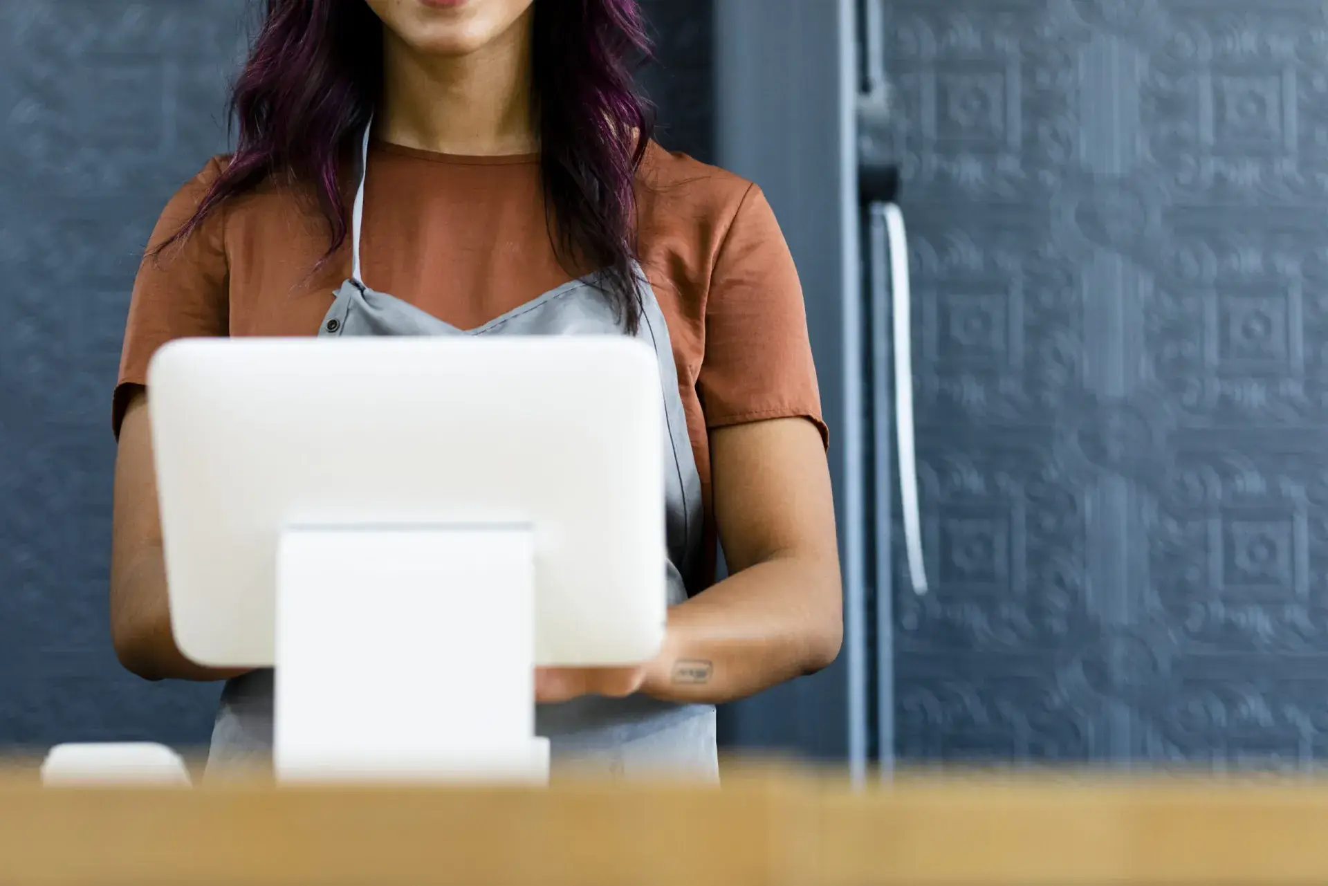 Cashier standing behind a point-of-sale till in a shop