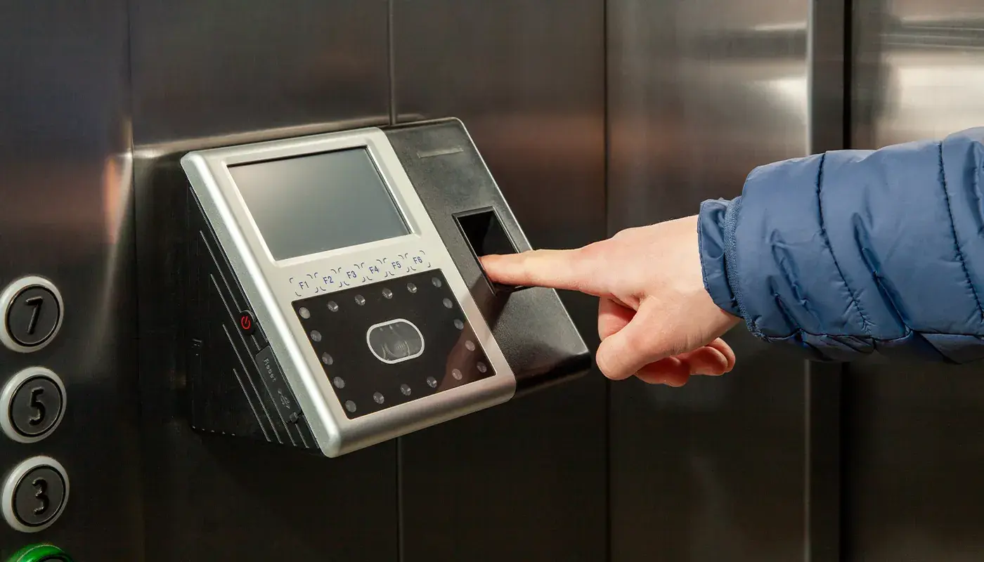 Access control for businesses in the Eastern Cape: finger on a fingerprint and facial recognition access terminal beside a lift