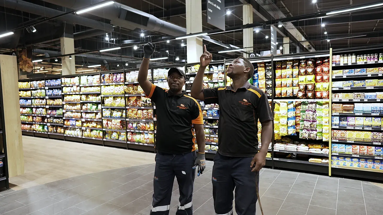 CCTV installation in Boksburg, Gauteng: CCTV Security Surveillance technicians checking camera coverage in a store aisle