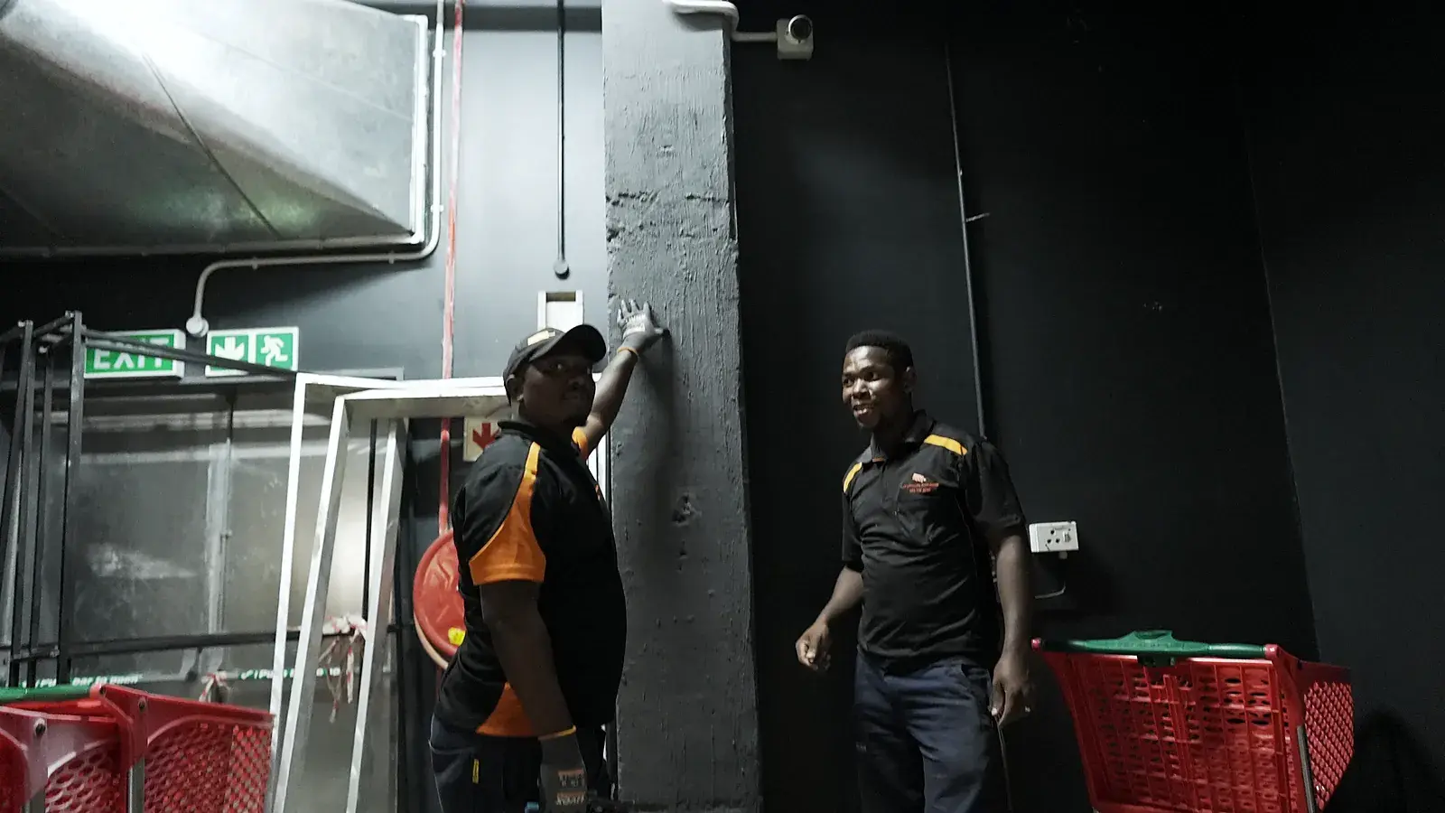 CCTV installation in Epping, Western Cape: CCTV Security Surveillance technicians fitting equipment at a store's back-of-house exit
