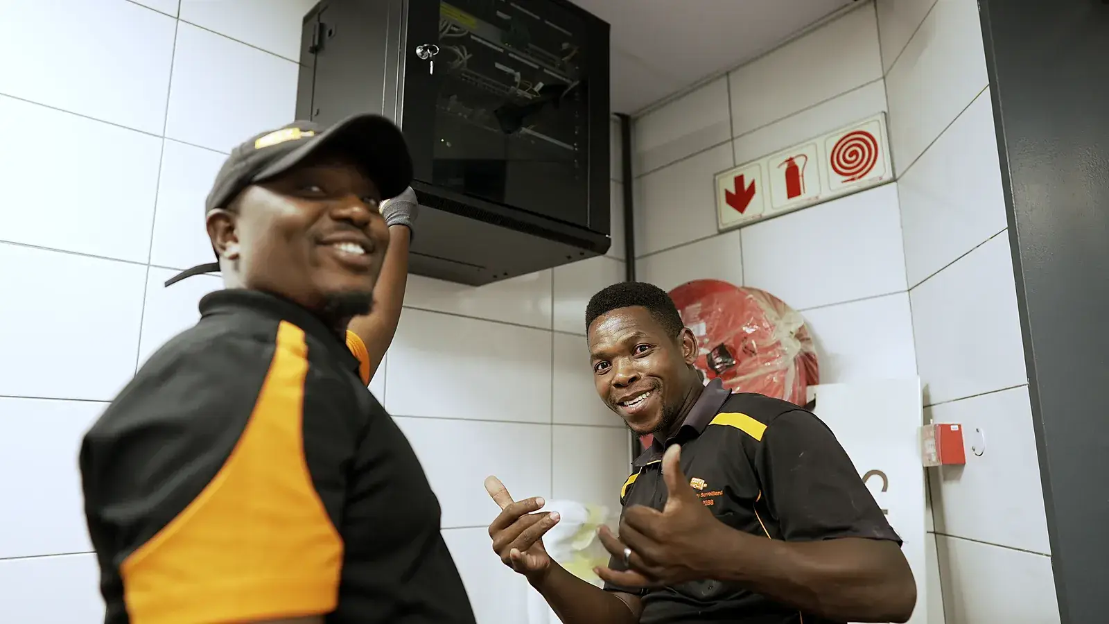 CCTV installation in Jeffreys Bay, Eastern Cape: CCTV Security Surveillance technicians beside a wall-mounted CCTV cabinet