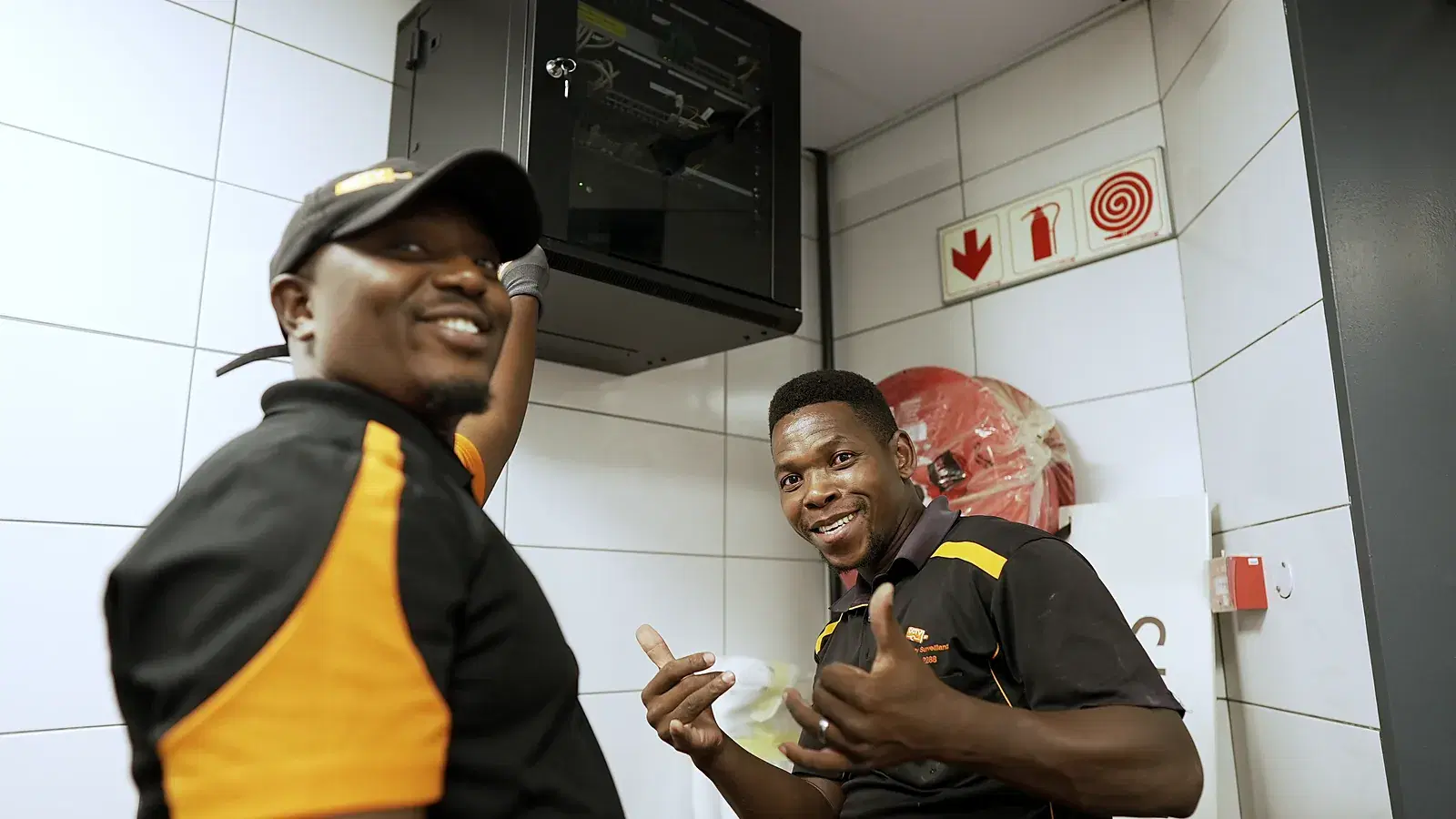 CCTV installation in Jeffreys Bay, Eastern Cape: CCTV Security Surveillance technicians beside a wall-mounted CCTV cabinet