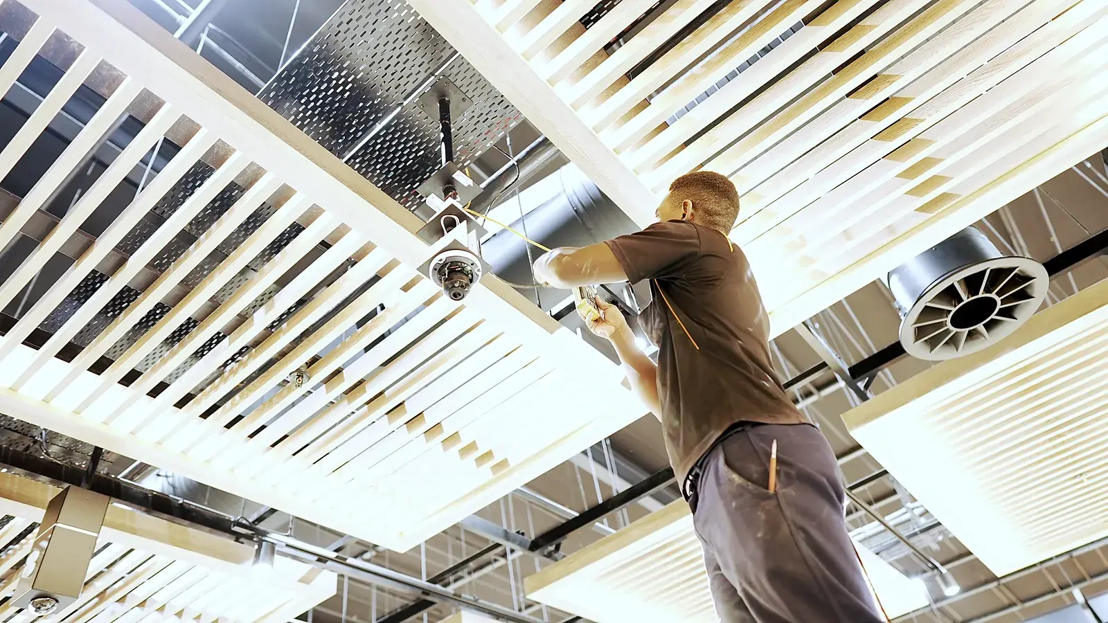 CCTV installation in Gauteng: CCTV Security Surveillance technician mounting a CCTV dome camera on a store ceiling