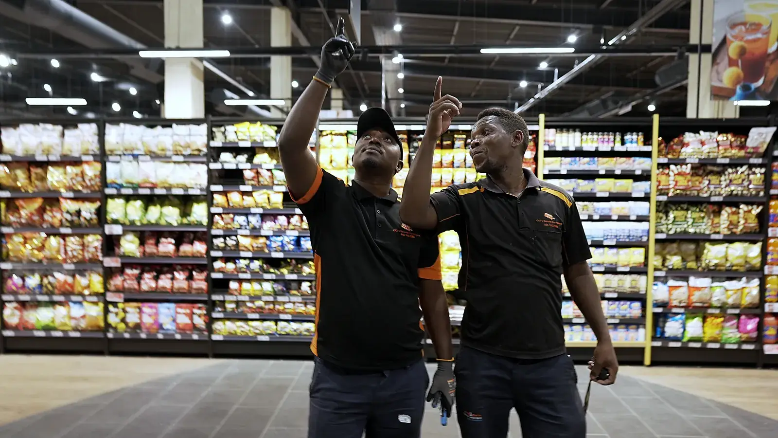 CCTV installation in Roodepoort, Gauteng: CCTV Security Surveillance technicians checking camera coverage in a store aisle