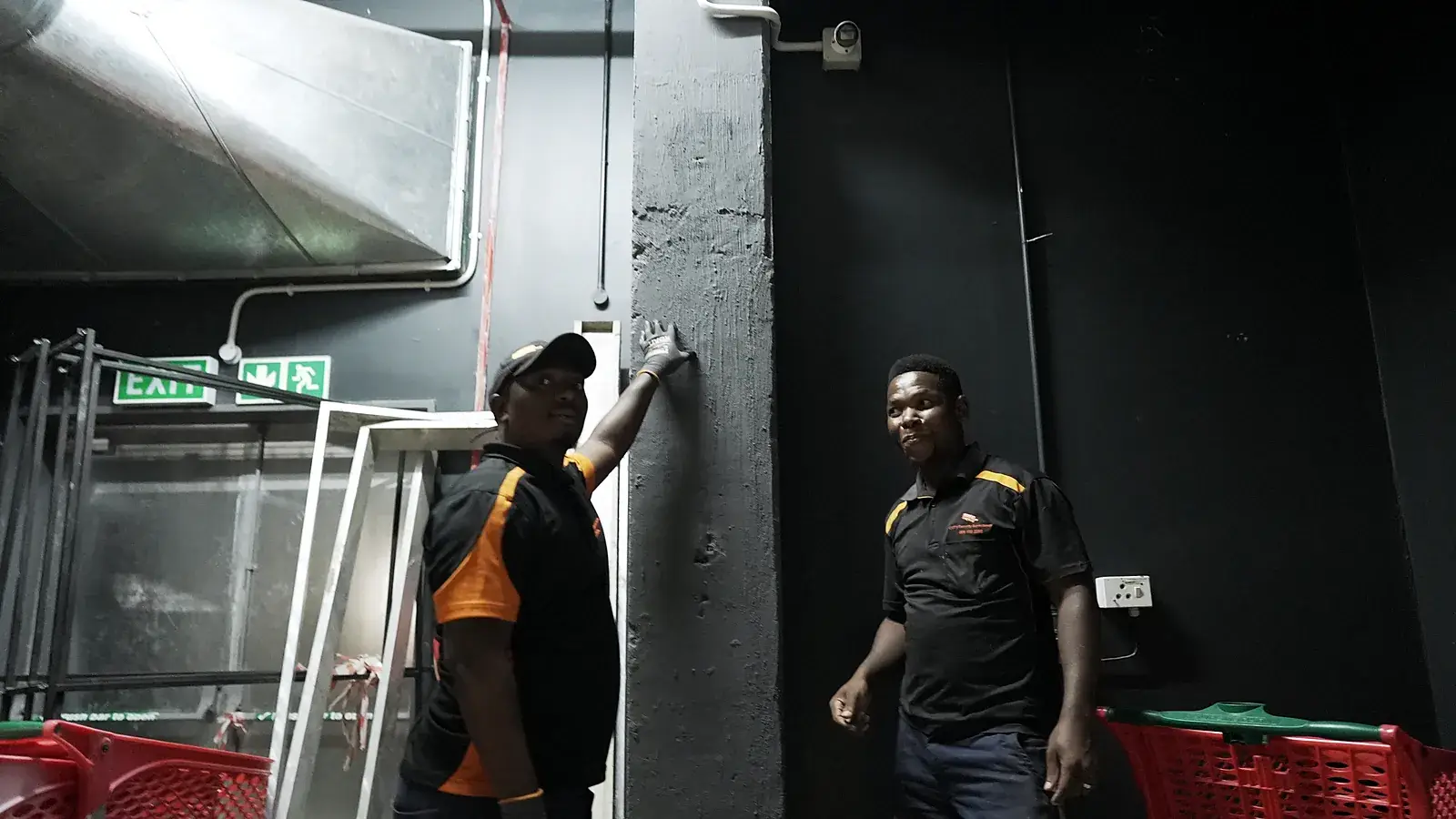 CCTV installation in South Durban, KwaZulu-Natal: CCTV Security Surveillance technicians fitting equipment at a store's back-of-house exit