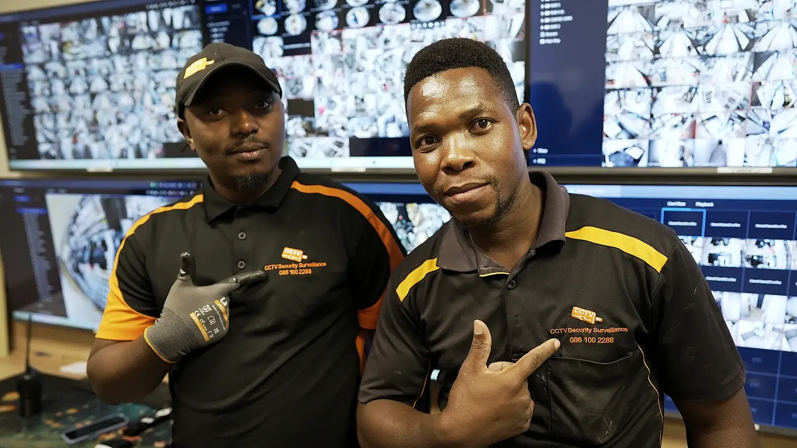 Two CCTV Security Surveillance technicians in front of a CCTV monitoring video wall